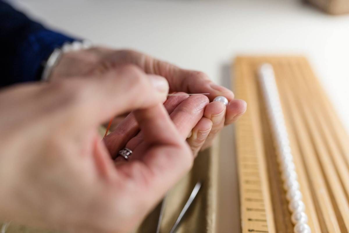 Reperatur Perlenkette mit Nadel und Faden